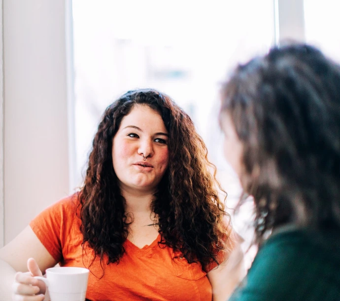 twee vrouwen kijken naar mekaar bij kop koffie